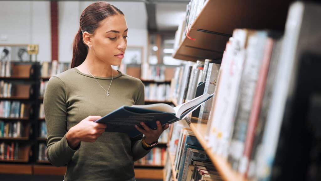 Young woman looking at a book in the library