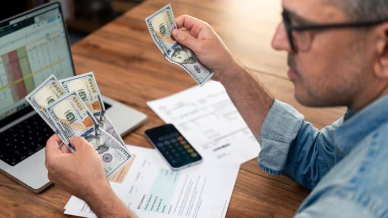 Man counting money and working on his budget