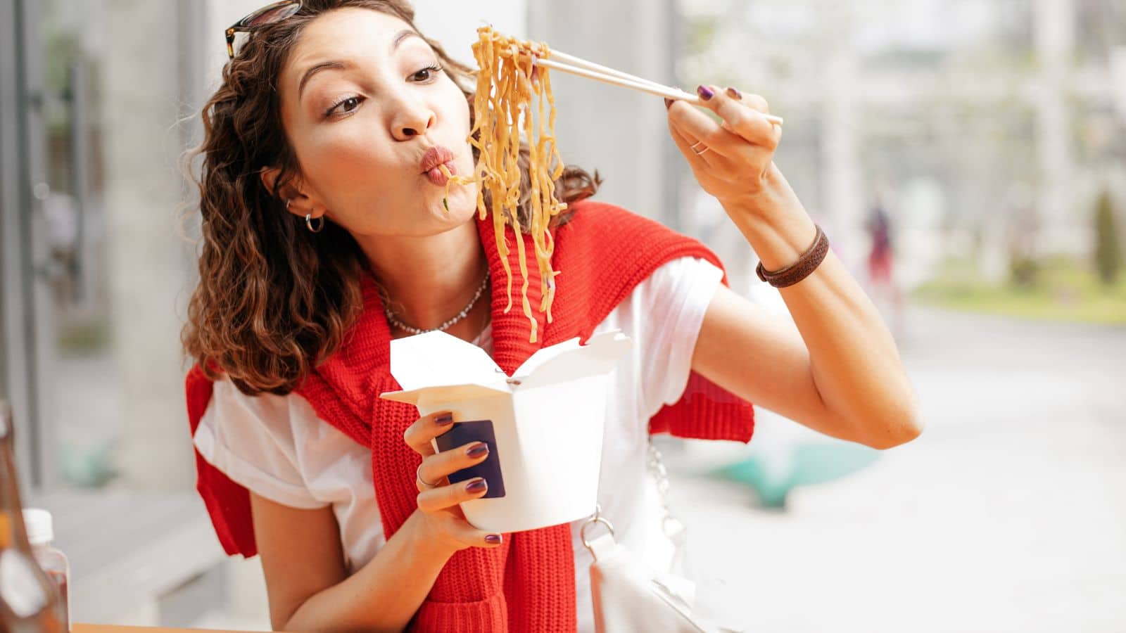 Woman eating a take out container of Chinese food