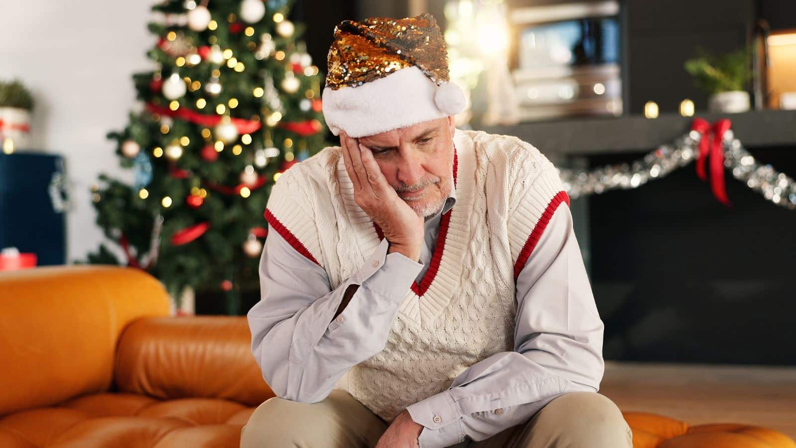 Older man wearing a santa hat looking sad