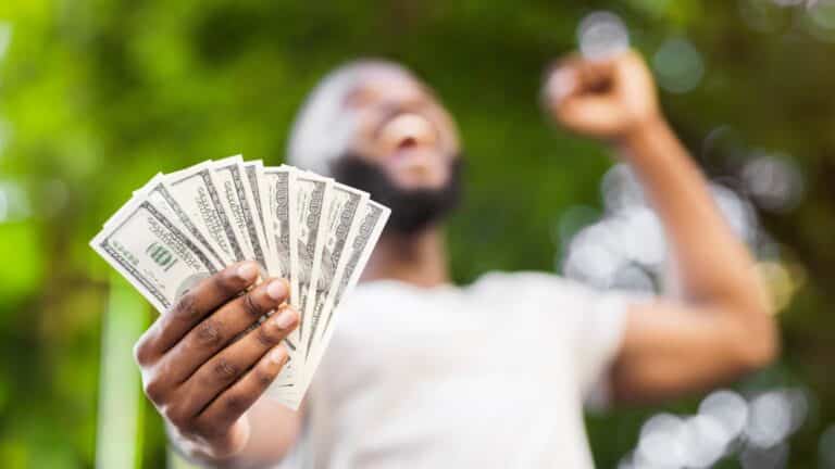 Man holding cash in his hand and cheering