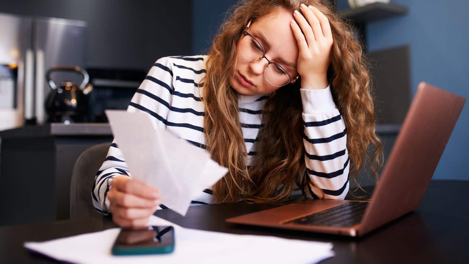 Woman looking at her paycheck and looking stressed