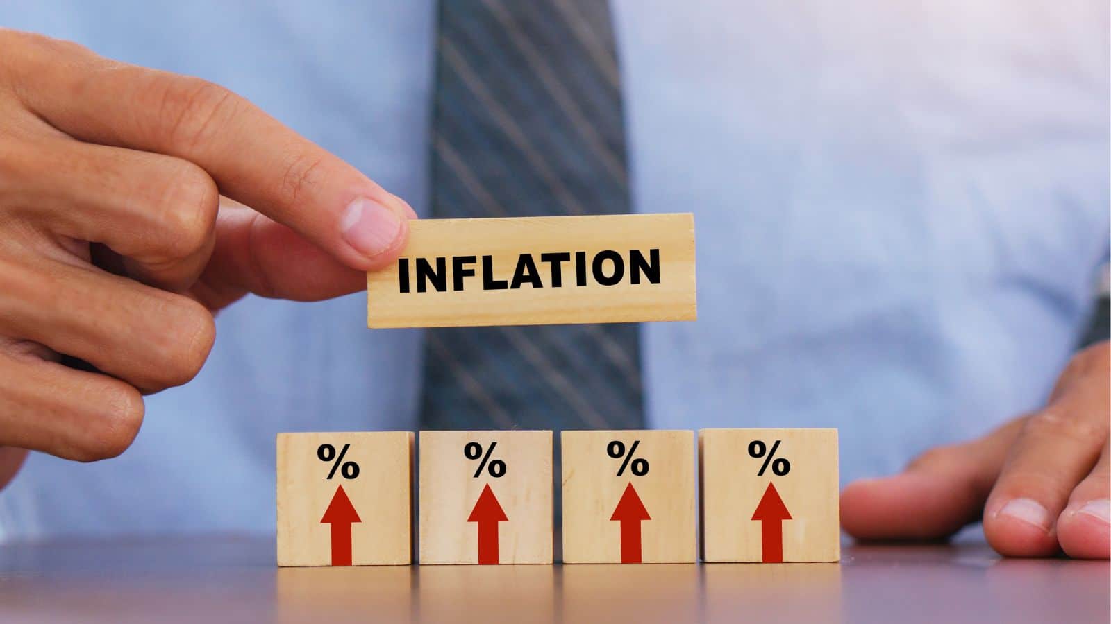 Man using wooden blocks that say 'inflation'