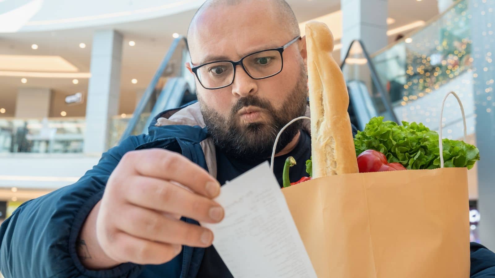 Man looking annoyed at his grocery receipt