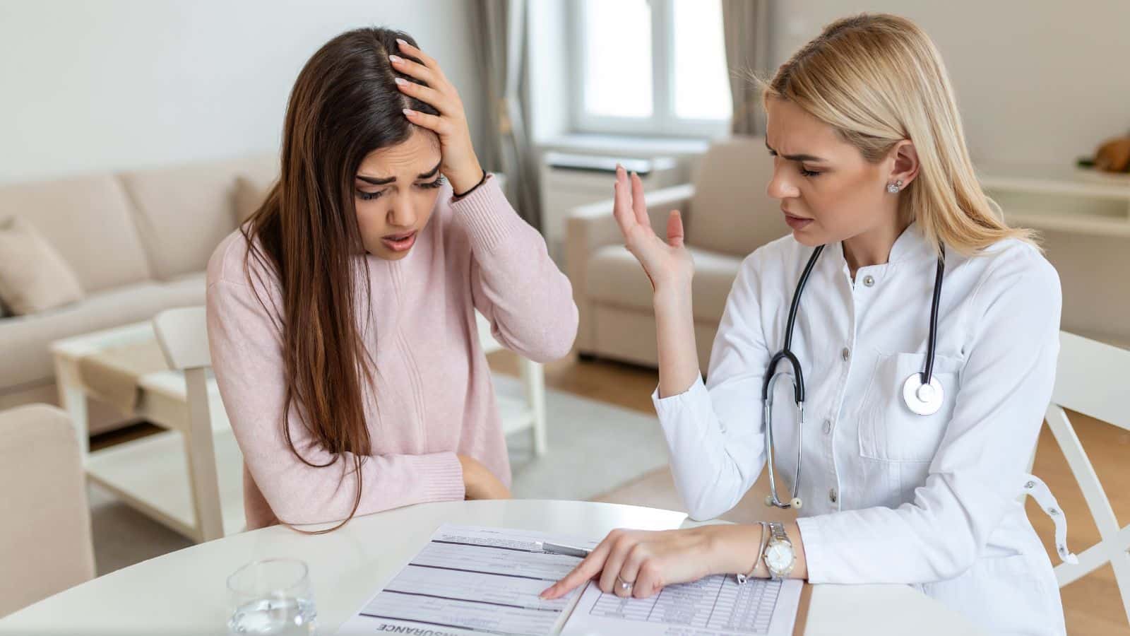 Doctor reviewing medical bills with a young female patient