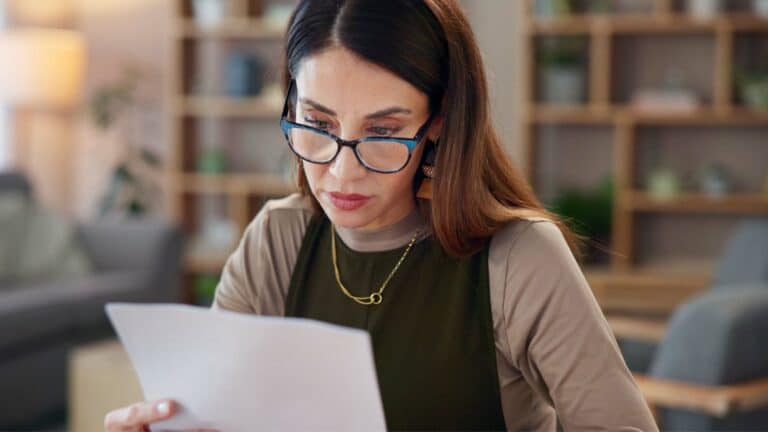 Woman looking shocked reading her credit card statement