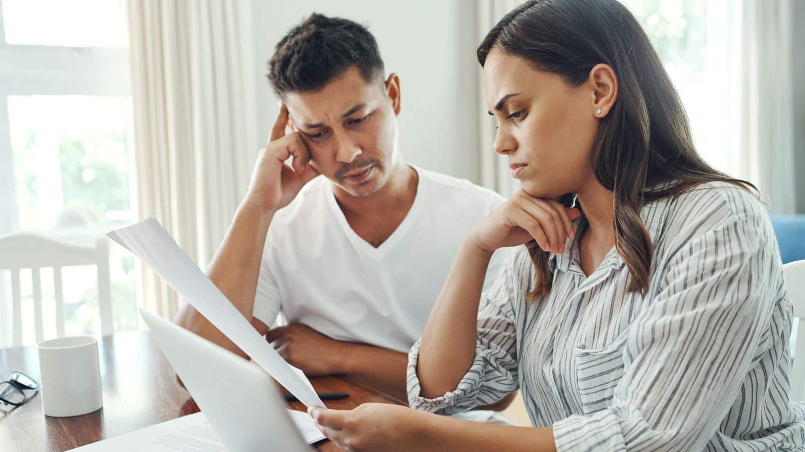 Couple looking stressed while paying bills
