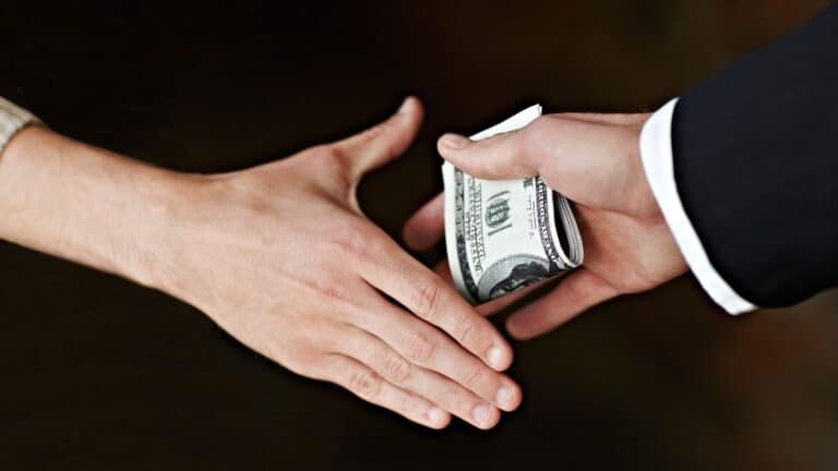 Man giving money in hand to another man