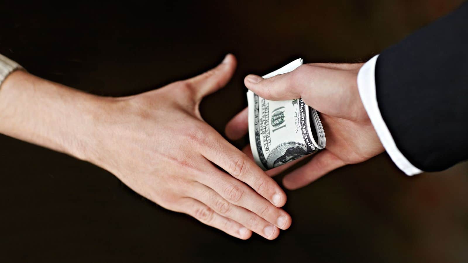 Man giving money in hand to another man