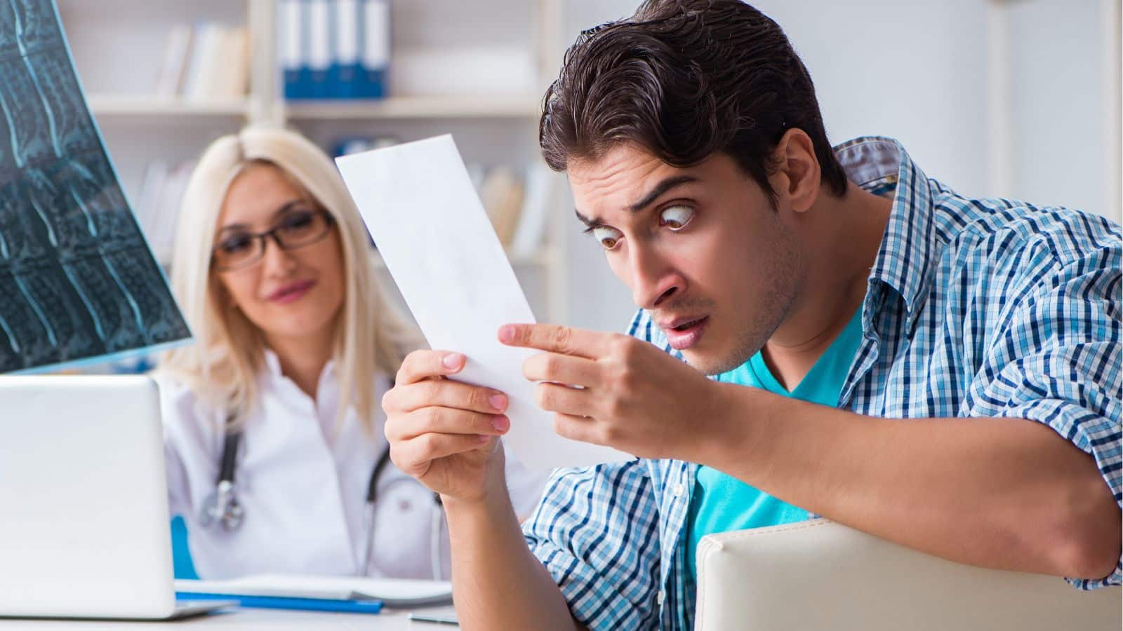 Man sitting with doctor looking upset at a bill