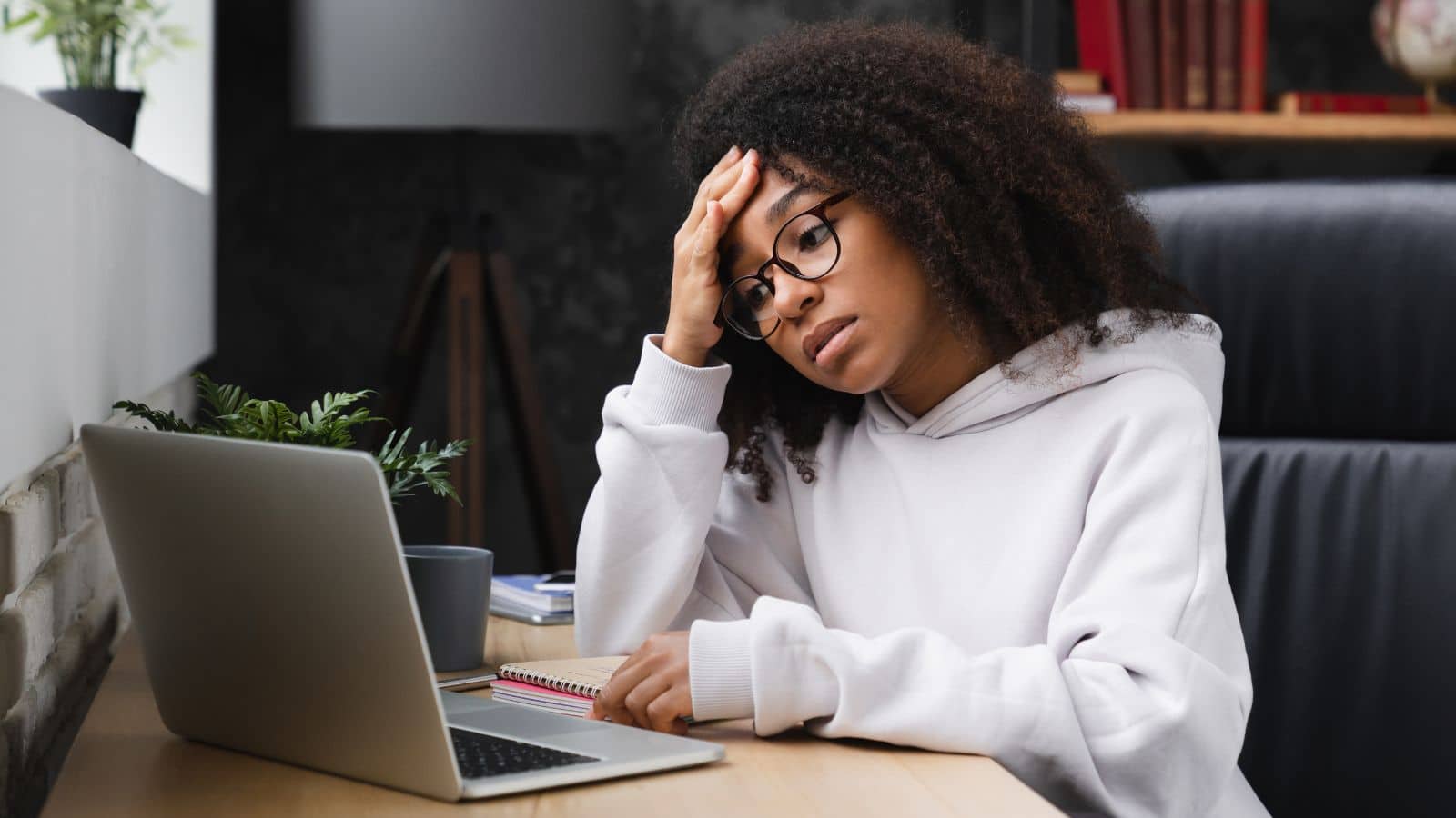 Young woman sitting at her computer looking very worried