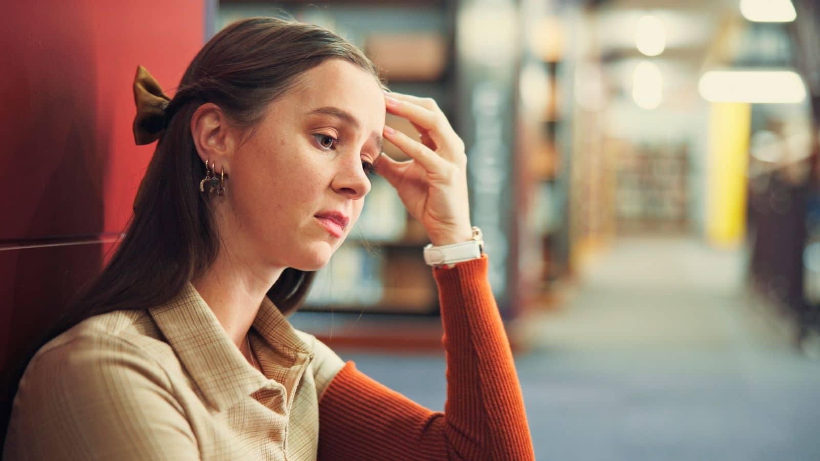 College girl sitting on floor looking upset