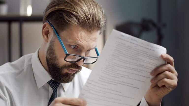 Man looking shocked at a bill he opened