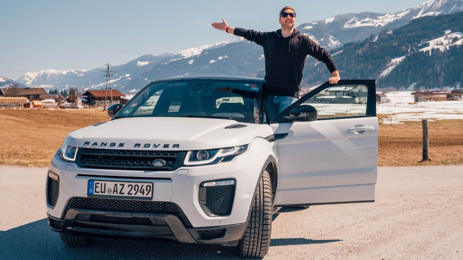 Man hanging out the door of a Range Rover
