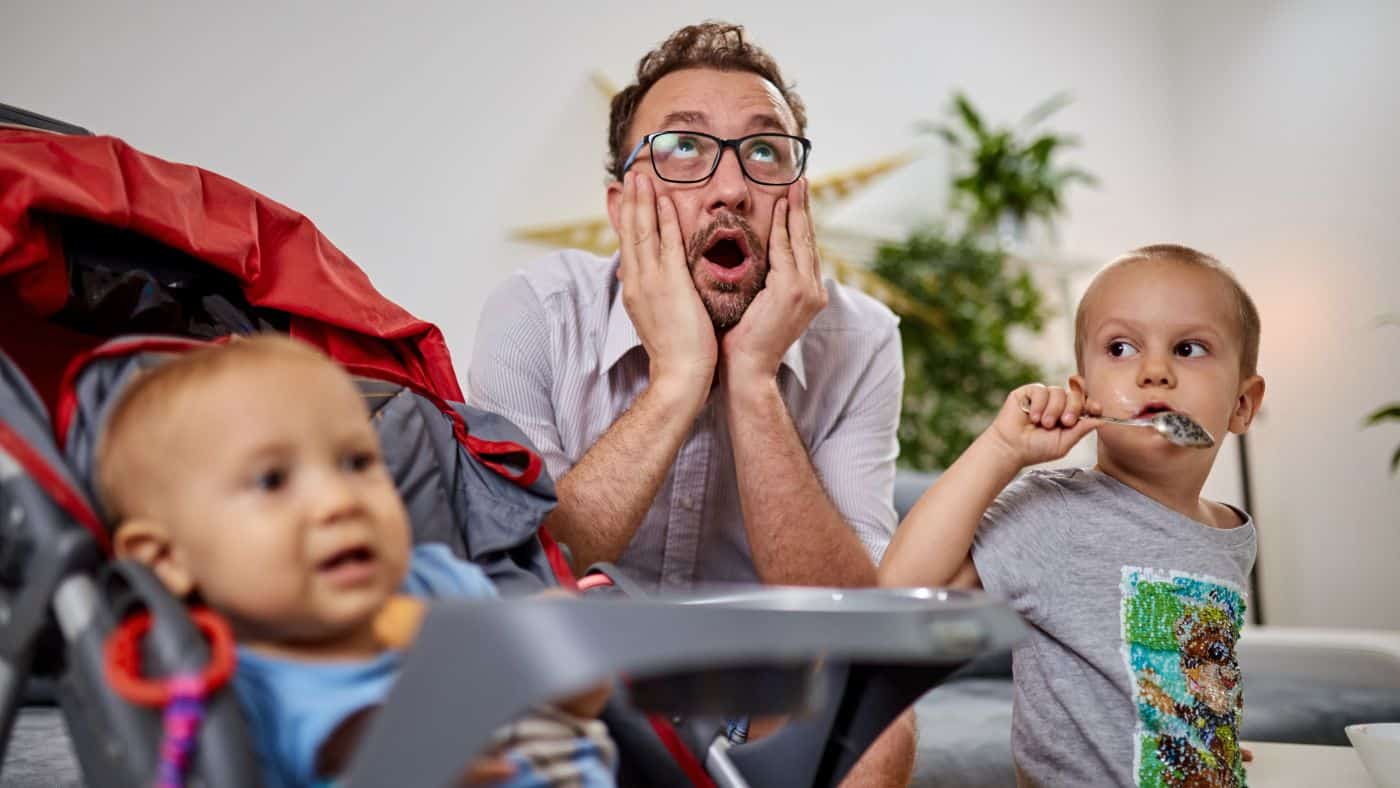 Man with two small kids looking stressed