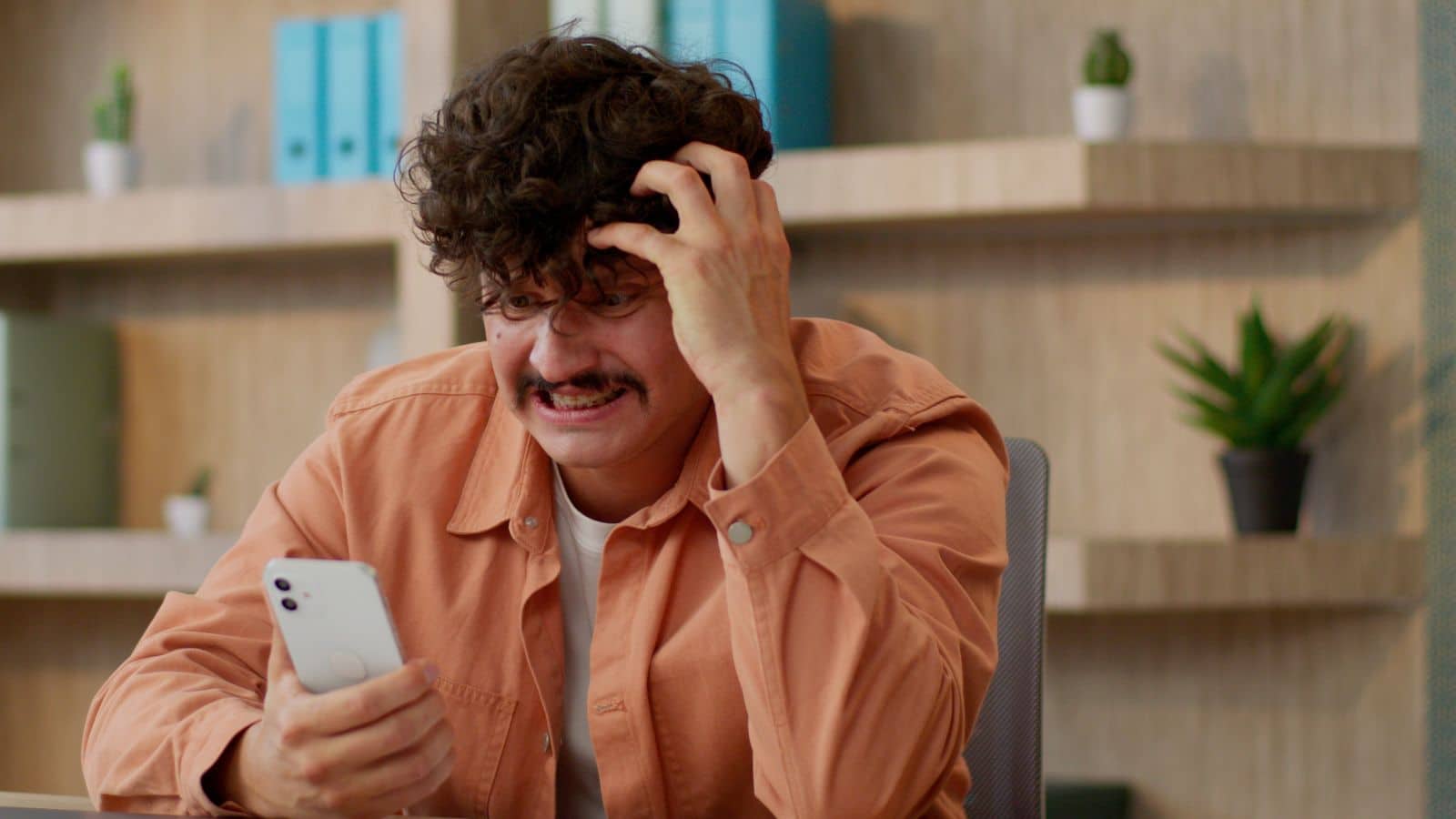 Man looking frustrated while looking at his phone