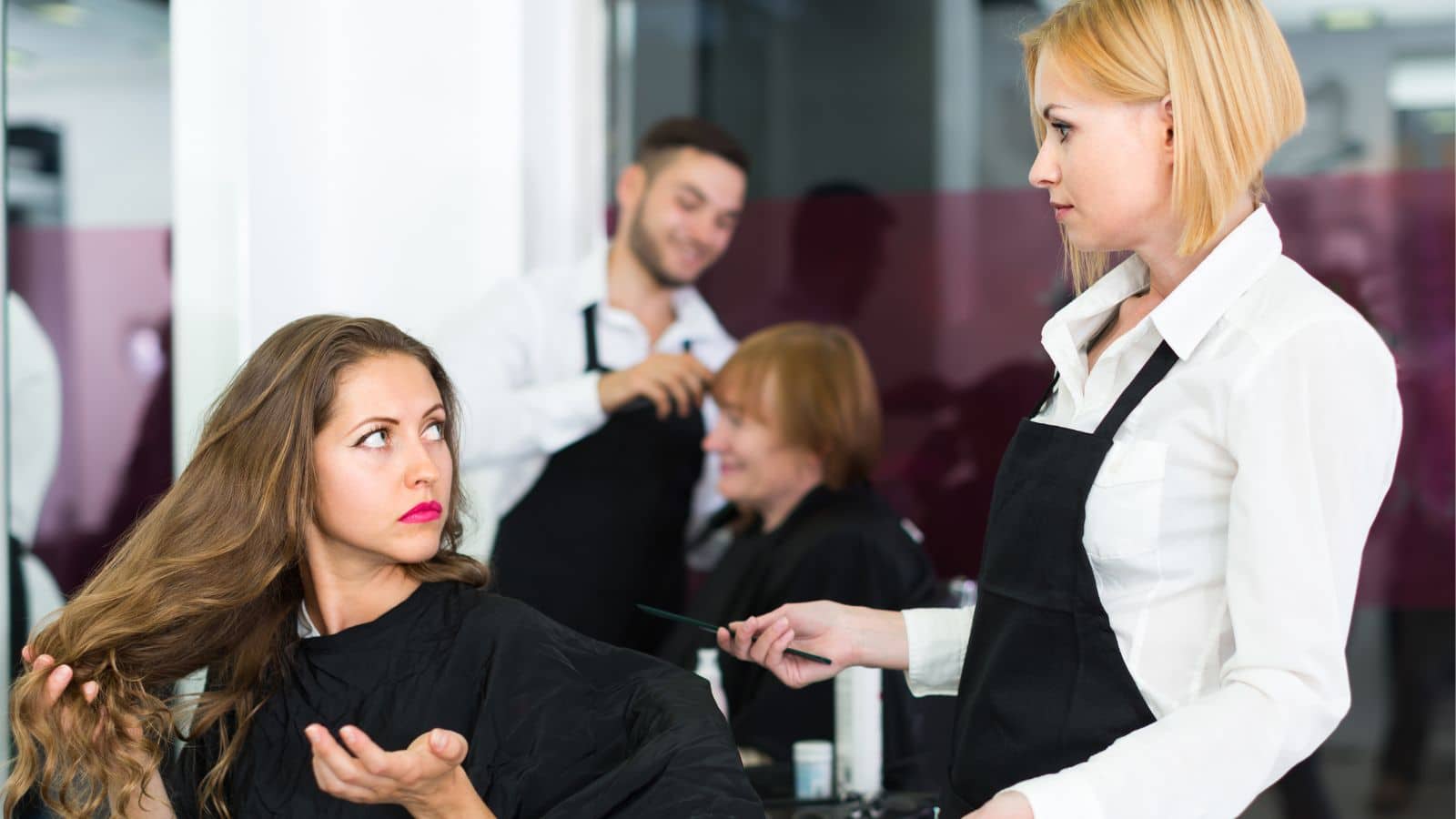 Hairdresser and customer looking annoyed with each other