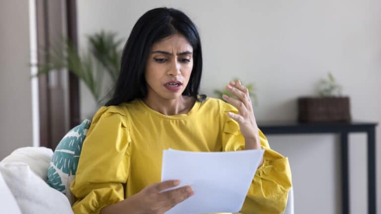 Woman looking upset as she looks at a bill