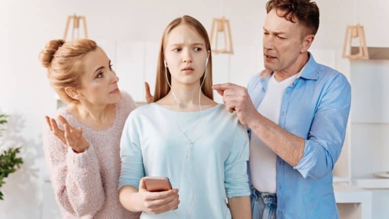 Parents leaning over their daughter in her face