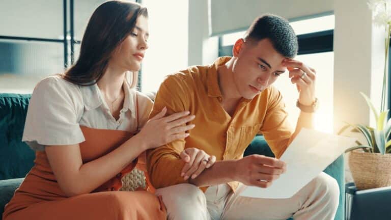 Couple looking at a paper looking worried