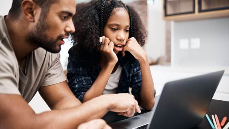 Dad using laptop with daughter