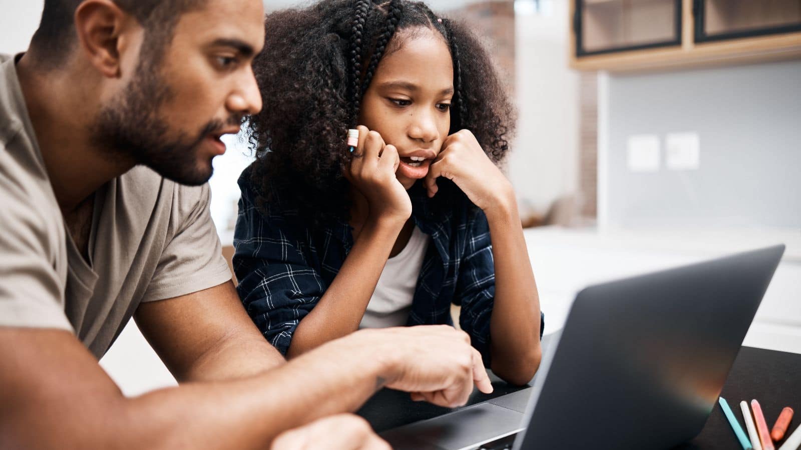 Dad using laptop with daughter