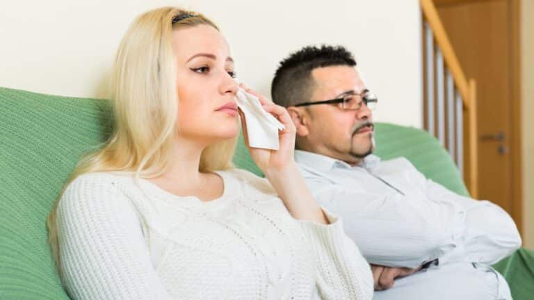 Couple sitting on couch looking upset