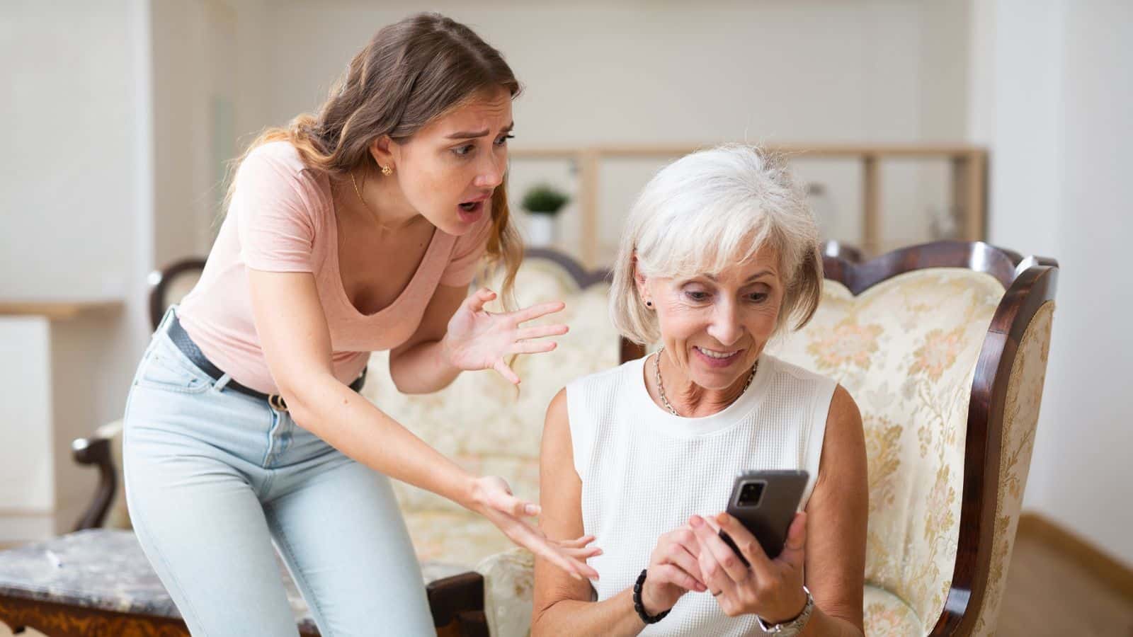 Daughter looking upset over something her mother is looking at on her phone