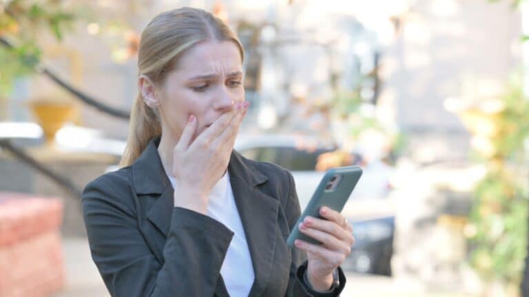 Young woman looking upset while looking at her phone