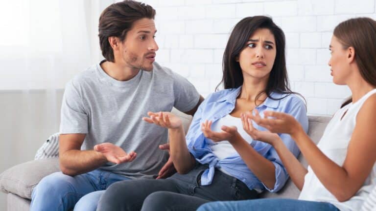 Adults sitting on a couch arguing