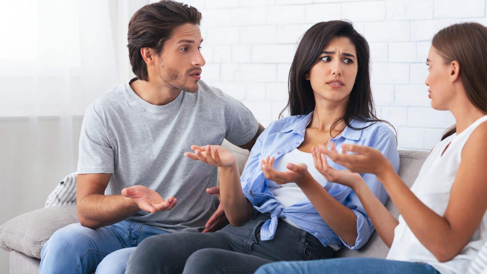 Adults sitting on a couch arguing