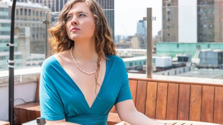 Woman sitting outside dressed up and looking sad