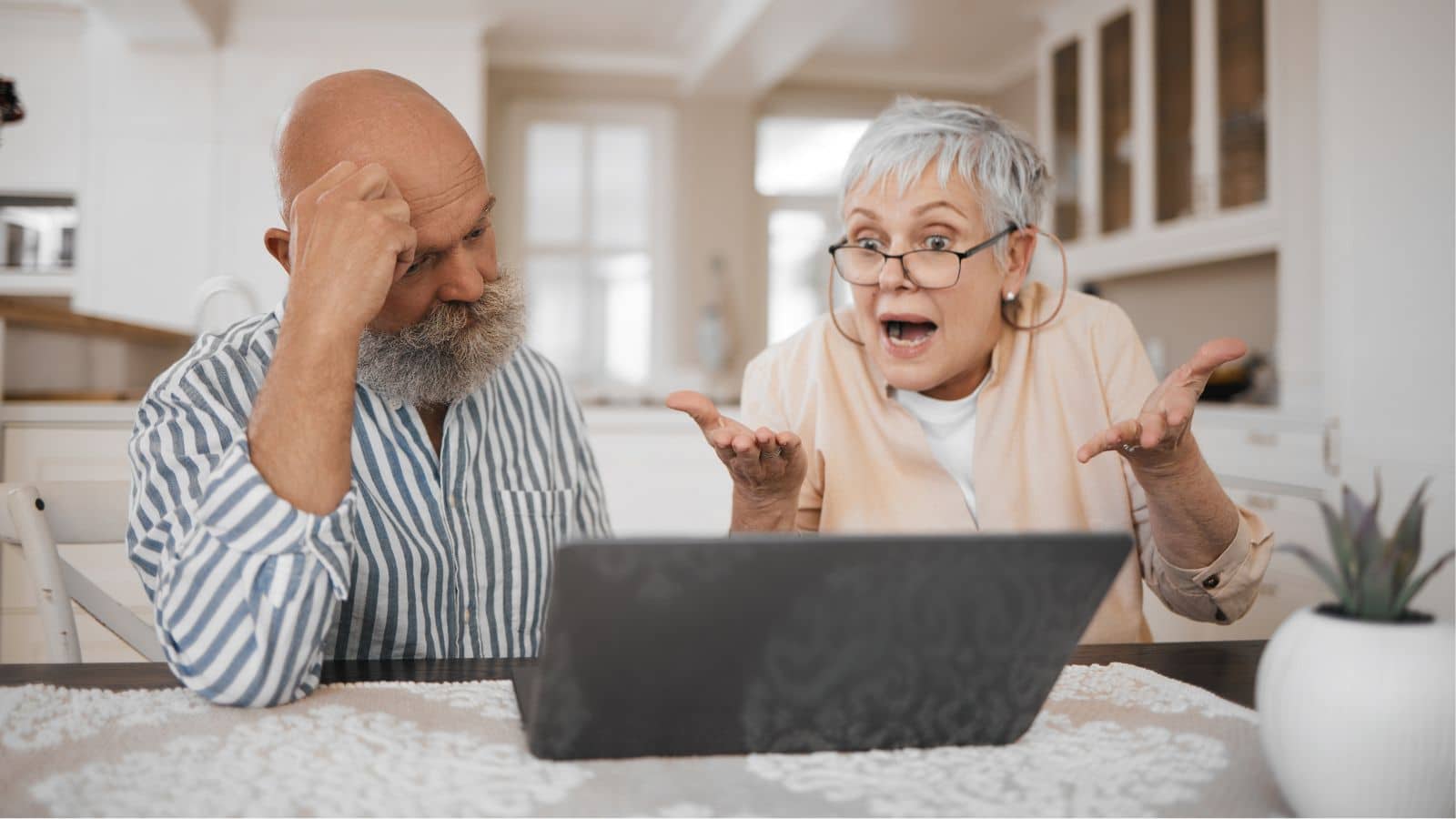 Older couple looking at laptop and looking annoyed