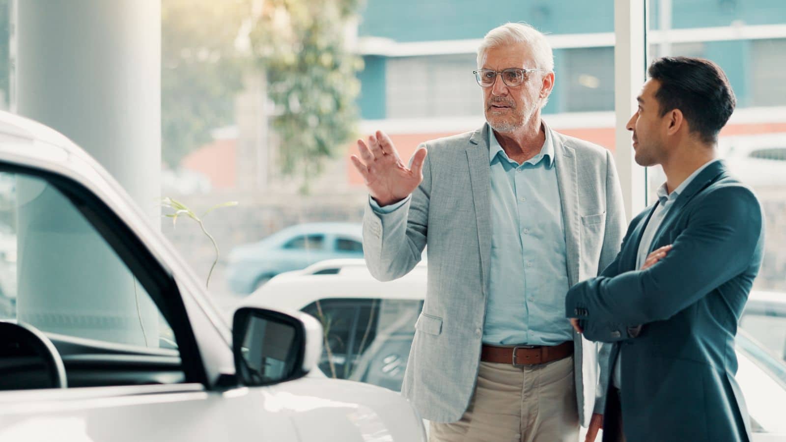 Man talking to car salesman and not looking happy