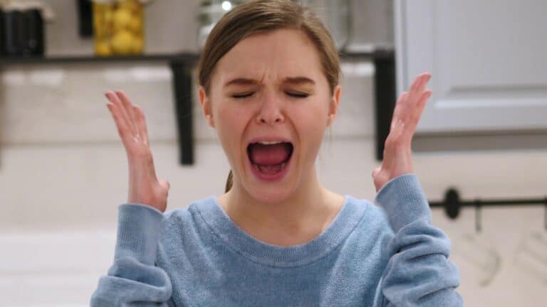 Woman holding her hands up in frustration and screaming