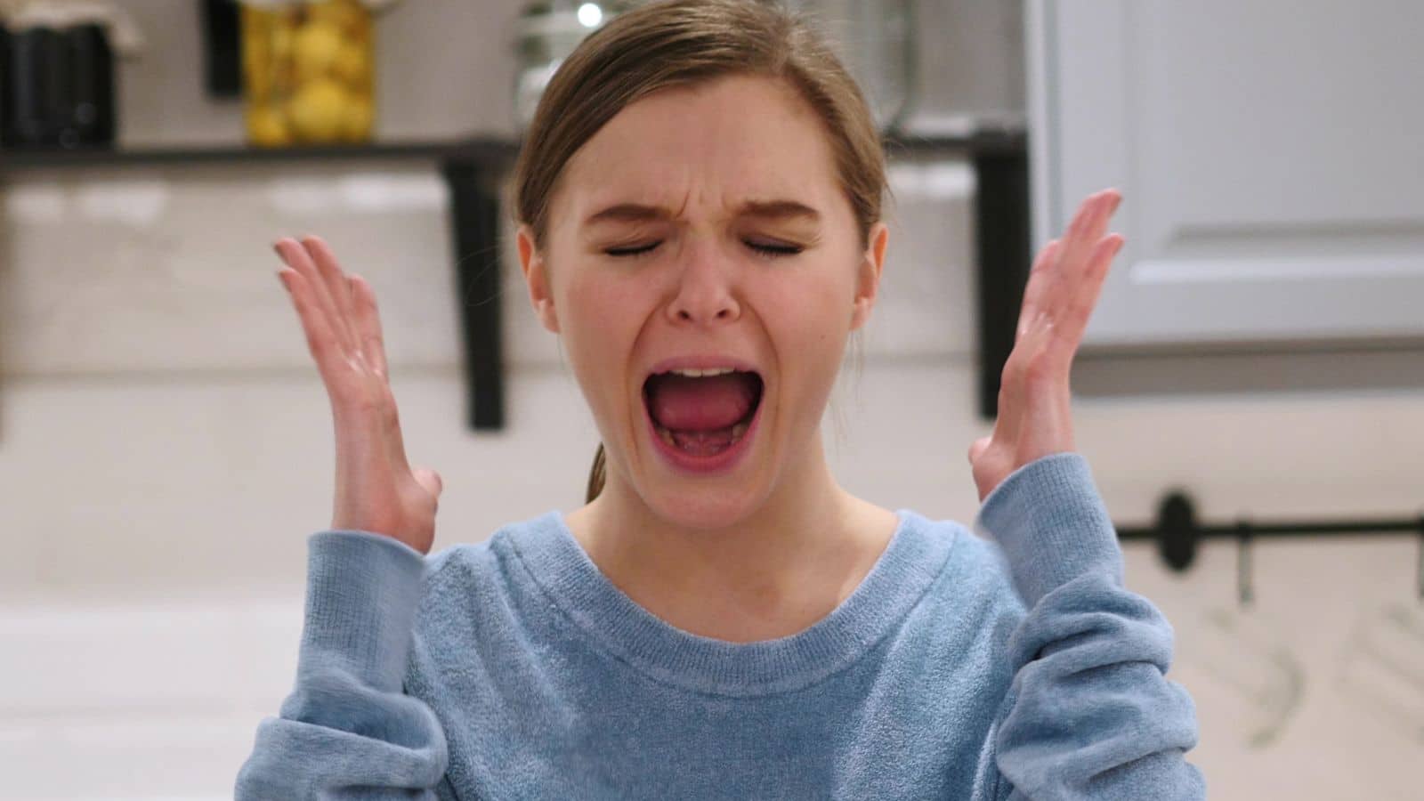Woman holding her hands up in frustration and screaming