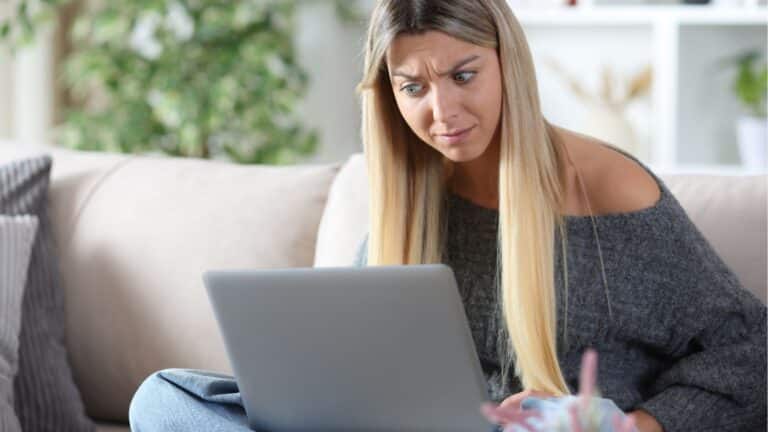 Young woman looking annoyed at her laptop