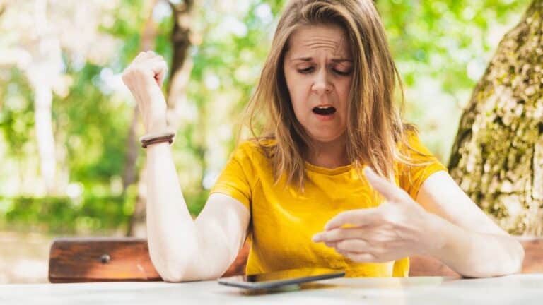 Woman looking upset while looking at her phone