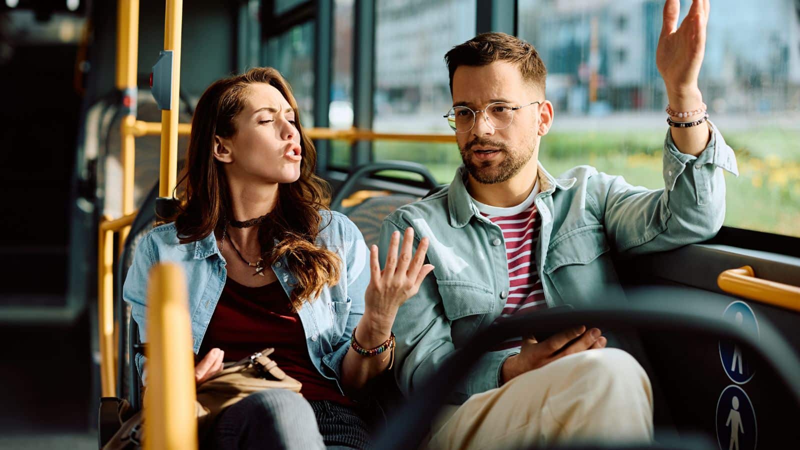 Couple sitting together and arguing on a bus